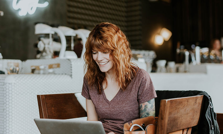 Red hair woman blogging at coffee shop