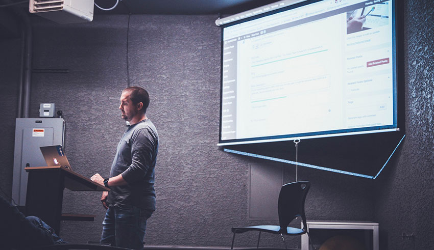 Speaker at an event showing slide presentation