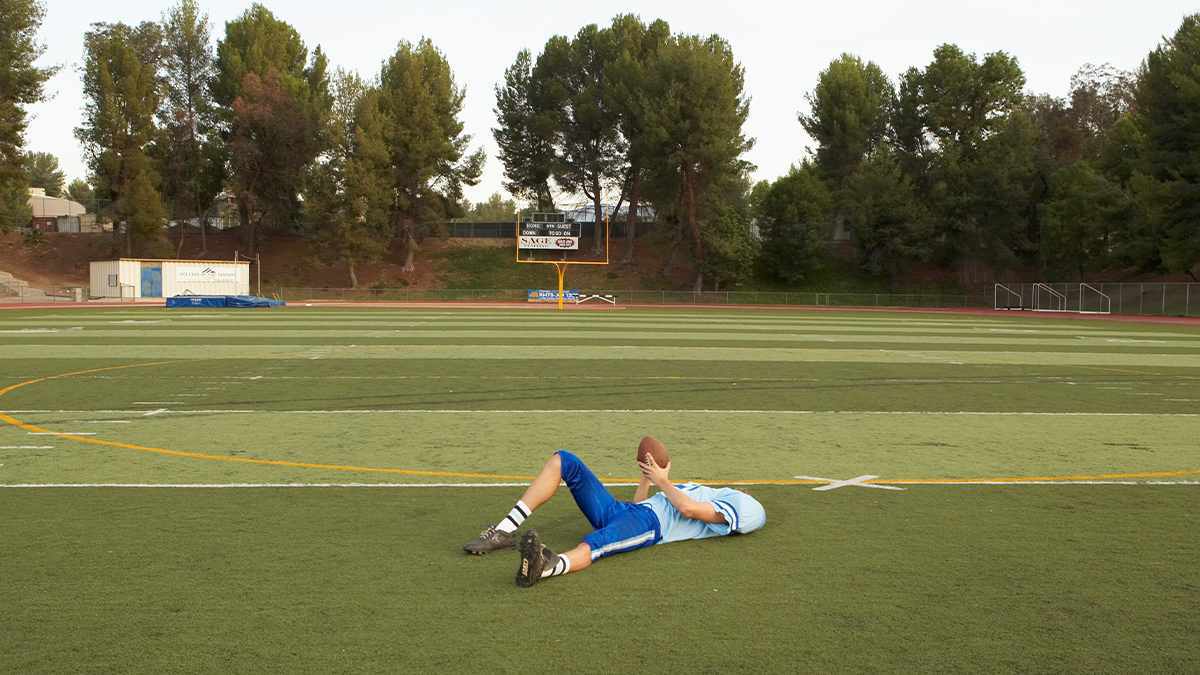 football player lying on the grass