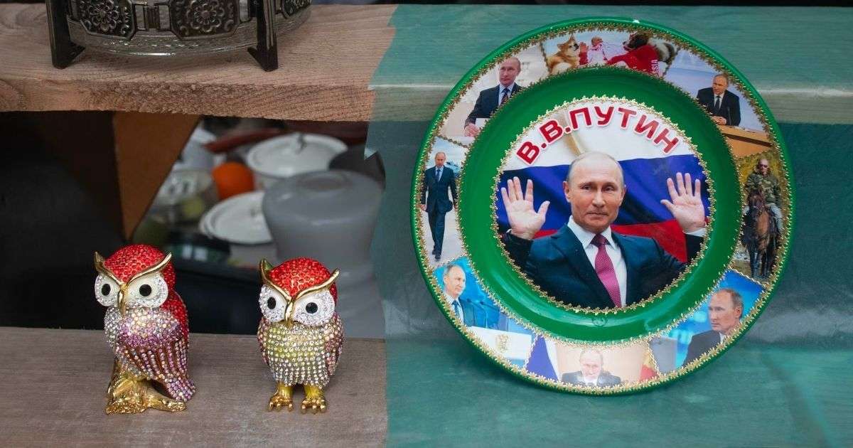 two bejeweled bird figures and a plate showing vladimir putin