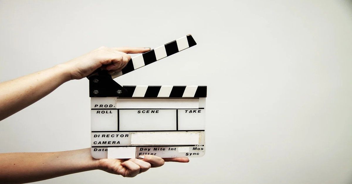 hands holding white and black movie slate