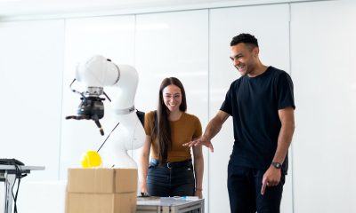 two people looking at a robotic arm