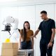 two people looking at a robotic arm