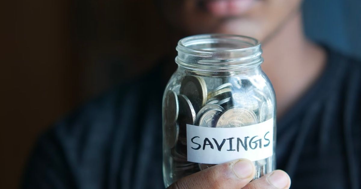 person holding a jar of coins