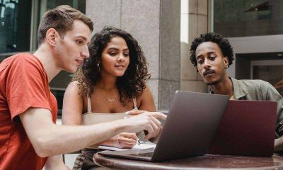 three people looking at a laptop