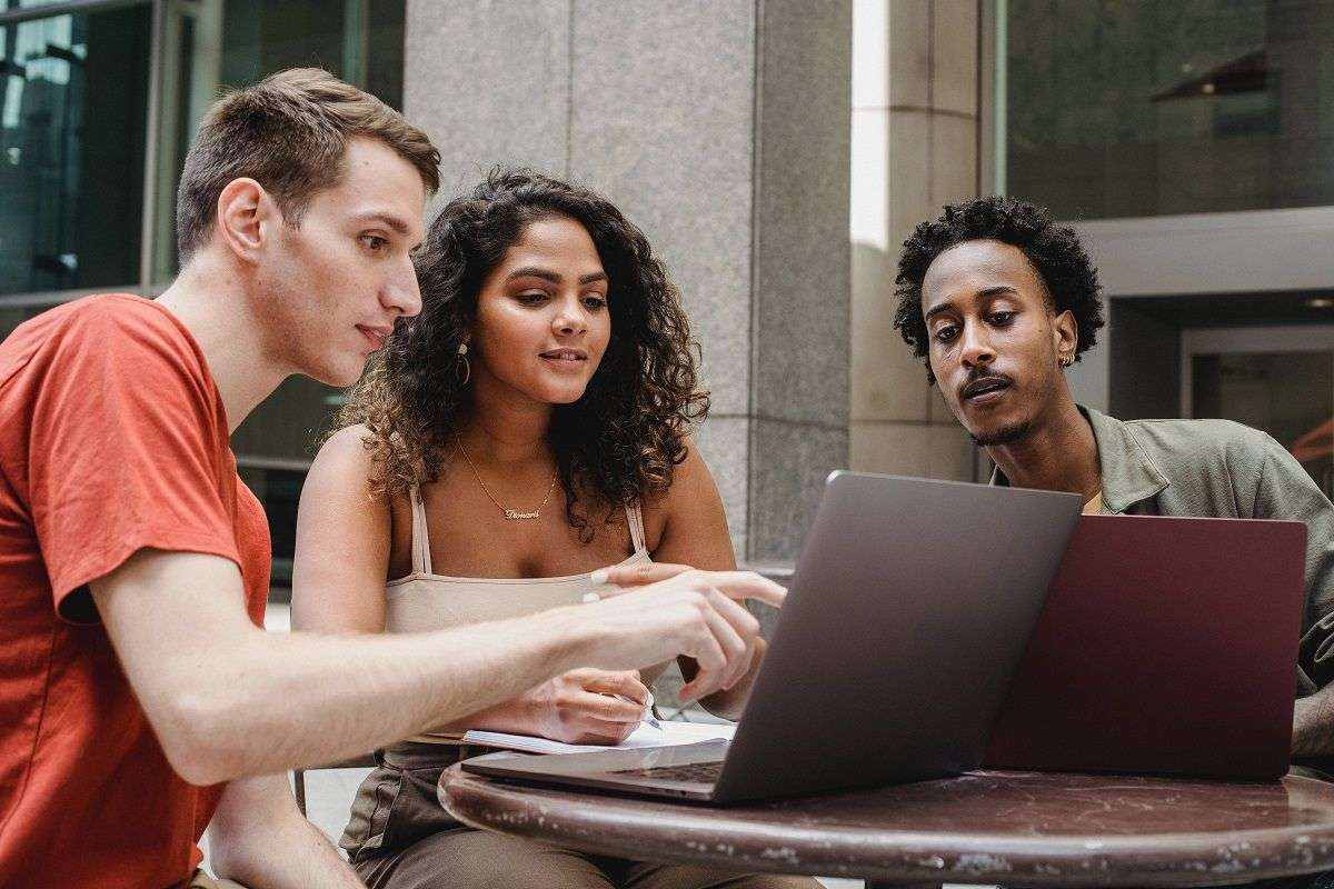 three people looking at a laptop