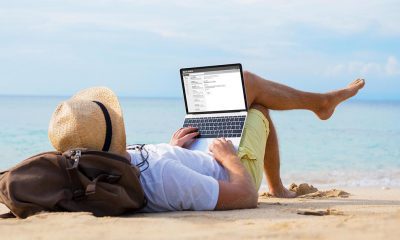 person using a laptop at the beach
