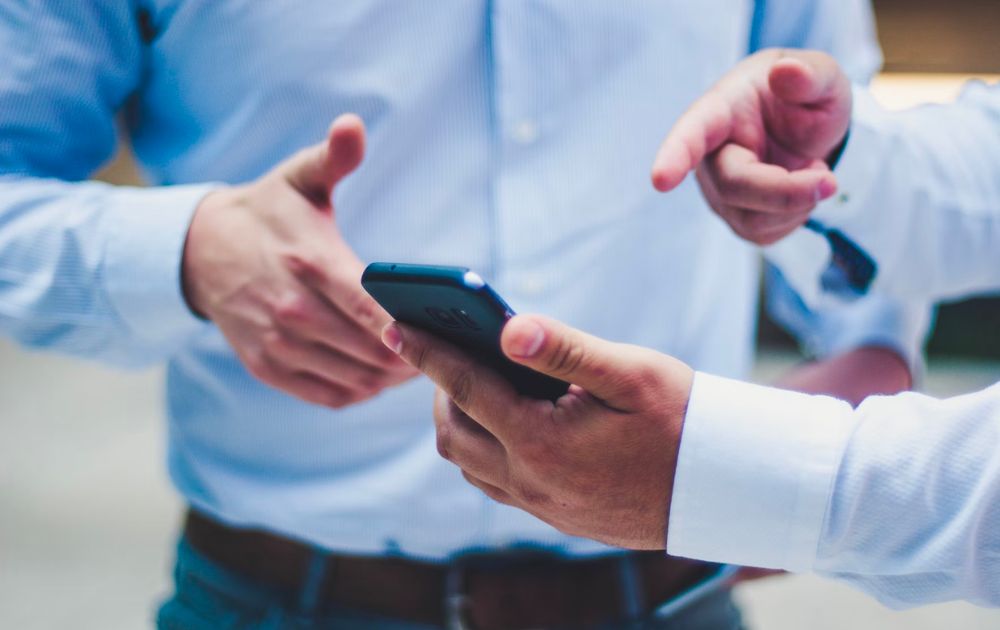 people pointing at a smartphone