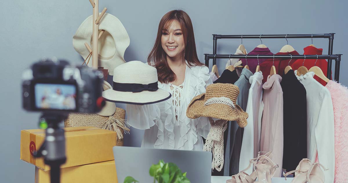 woman holding two hats