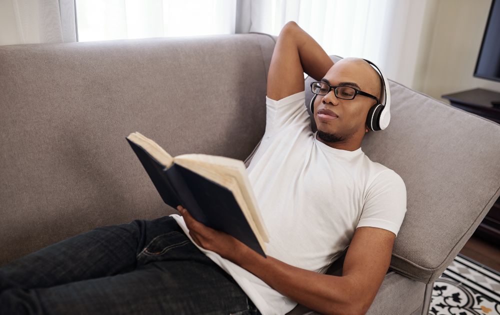 man wearing headphones and reading a book